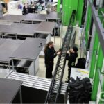 Mitarbeiter von ETNord montieren Traversen für Veranstaltungstechnik in der Werkstatt.