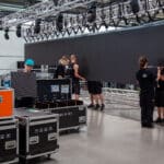 Aufbau einer großen LED-Wand durch Eventtechniker, umgeben von Traversen, Cases und sonstiger Veranstaltungstechnik.
